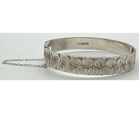 A vintage silver hinged bangle with circular engraved pattern and safety chain. Hallmarked Birmingham 1974. Total weight appr