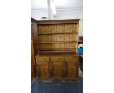 A Pine Kitchen Dresser, The Base with Three Drawers Over Cupboards and Raised Three Shelf Plate Rack with Dentil Cornice, 137