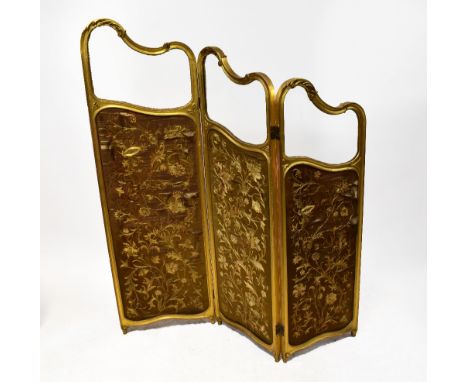 A 19th century three-panel gilt screen, each panel with a Rococo-style scroll top and bevelled glass panels, above brown embr