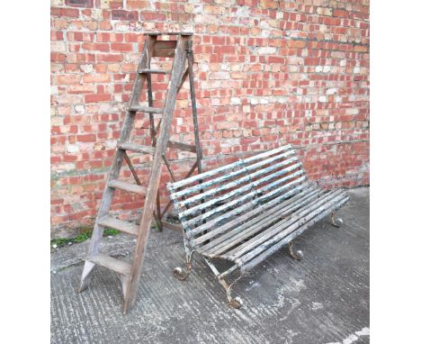 A wrought iron framed slatted garden bench, approx 74 x 183 x 70cm (af) and a vintage Woodware 'A1' folding stepladder. CONDI