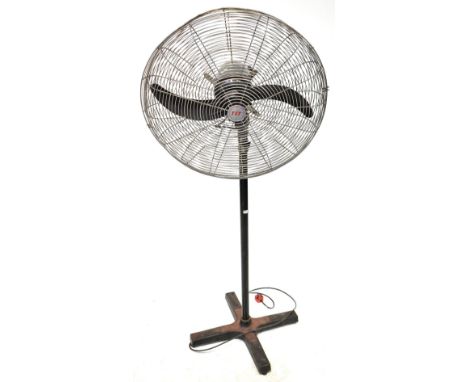 A large vintage floorstanding fan, stamped to the back of the motor 'TAT', and raised on a telescopic stand to a cast iron fo