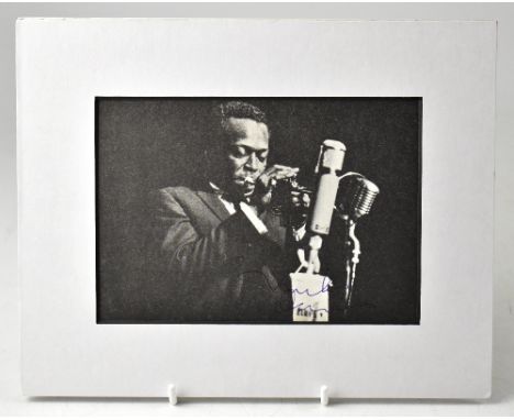 MILES DAVIS; a cut photograph from a book or magazine bearing the Jazz star's signature, 11.5 x 16.5cm, mounted.We have not a