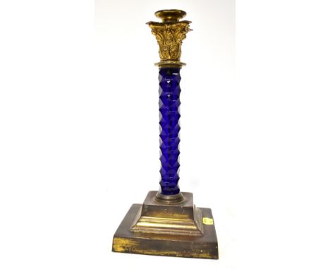 A 19th century cut glass and brass candlestick, the tall candlestick with Corinthian top with moulded acanthus leaves, raised