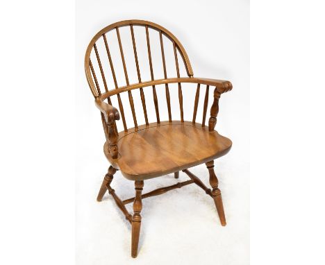 A 1980s reproduction Logatec Yugoslavia stick back Windsor chair of wide body and carved scroll handles.