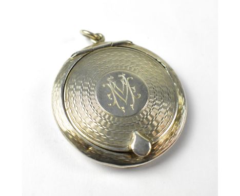 An Edwardian silver pendant compact of circular form with engine turned decoration, the central cartouche initialled 'MM', di