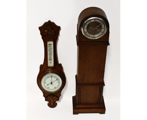 An oak cased granddaughter clock with key wind chiming movement, the silvered chapter ring set with Roman numerals, with dome