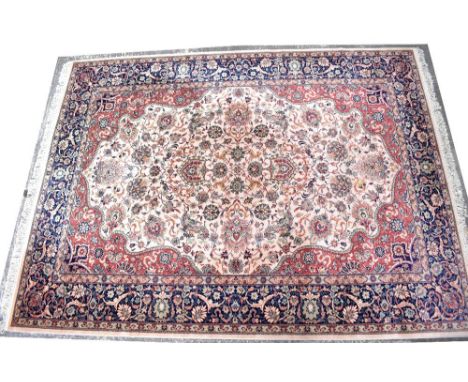 A vintage Persian carpet in blue, cream, red and green, with floral scrolling decoration within floral multi-borders, 274 x 3
