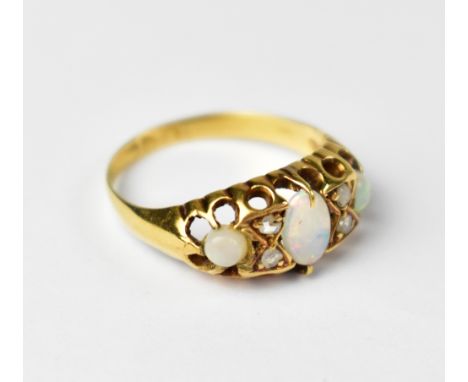 An 18ct yellow gold ring set with three opals and four small diamonds, size K, approx 3g.