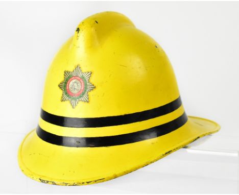 A vintage Merseyside Fire Brigade yellow helmet with printed badge to the front, 'Merseyside Fire Brigade', numbered to the i