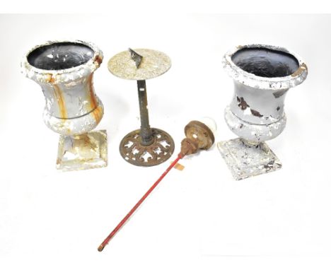 A composite sundial raised on a cast iron base, with pierced design to the circular foot, a pair of fibreglass Campana-form u