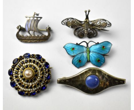 Four silver brooches comprising an enamelled blue and red dotted butterfly, a Celtic-style brooch with blue hardstone centre,