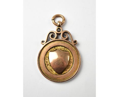 A George V 9ct rose gold prize fob, the circular fob with centred raised blank shield, inscription verso 'F.P.B.C. League Bis