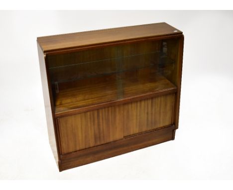 A retro mahogany glazed bookcase of small proportions, the tapering front with pair of sliding glass doors, enclosing a singl