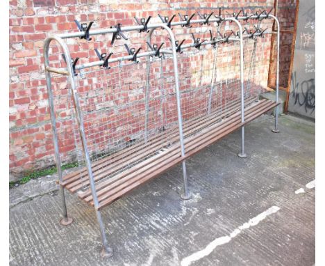 A vintage metal framed double-sided cloakroom bench, with two rows of coat hooks above a wire divider and slatted seat, each 