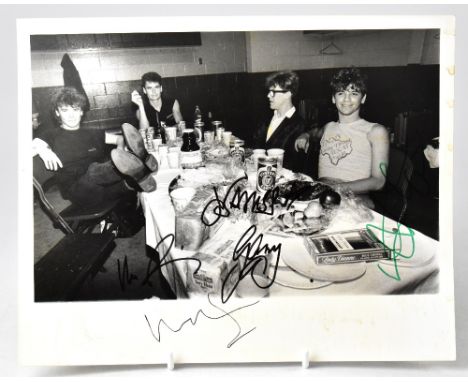 INXS; a promotional balck and white photograph featuring the band backstage and bearing the stars' signatures, 20 x 25.5cm, u