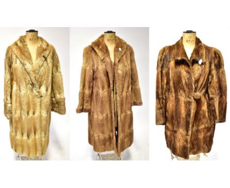 Three vintage fur coats comprising a camel-coloured coat with hook and eye fastenings and collar with brown lining, a cream a