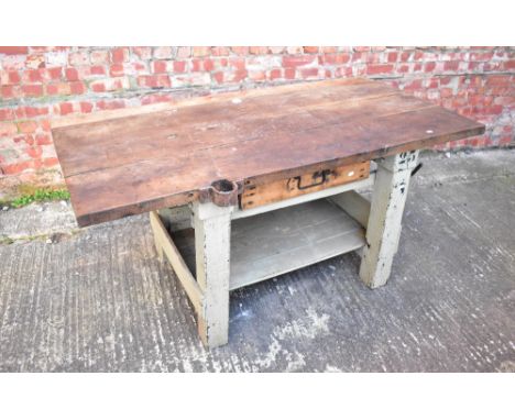 A vintage heavy workshop table of plank top construction, with painted base, single frieze drawer and galleried undertier, wi