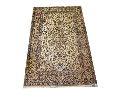 A large modern beige Kashan rug with cascading panels of floral patterns within a wide floral repeating border, on a beige/iv