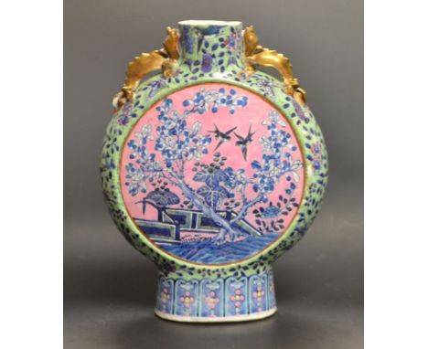 A  Chinese moon flask, decorated with song bird and blossoming branches in blue on a pink ground, the sides with scrolling fo