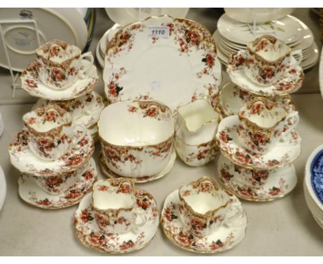A Staffordshire tea service decorated with summer flowers, comprising cake plate, ten tea plates, ten cups and saucers, milk 