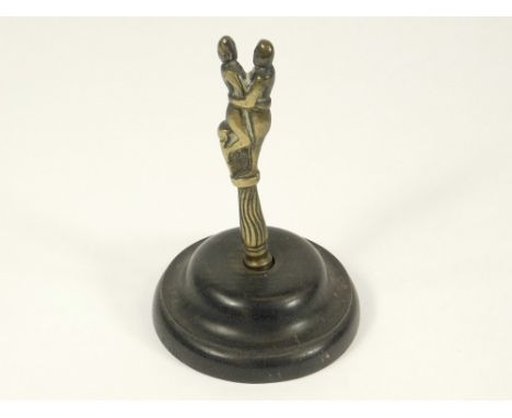 PIPE TAMPER. A brass pipe tamper, loosely mounted on a later turned ebonised base. Recovered from the wreck of H.M.S. Colossu