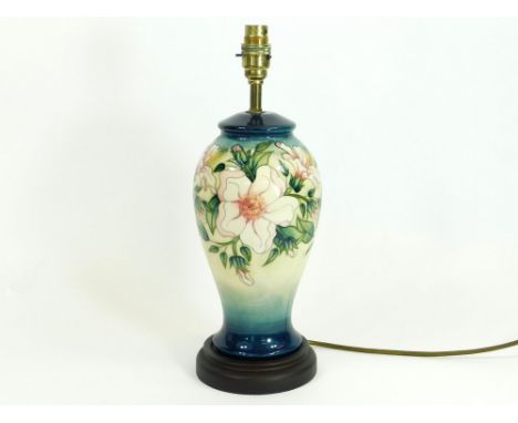 MOORCROFT. A Moorcroft lamp base on wooden stand. Height including base & fitting, 39cm.  Please note: For safety, all used l