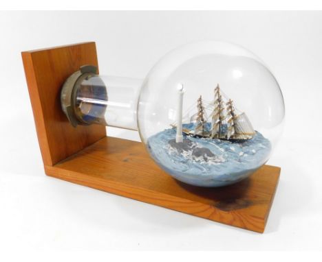 LIGHTHOUSE BULB. An early 20th century light bulb containing a model of the Longships Lighthouse with a 3-masted schooner pas