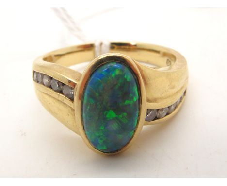 An Australian Black Opal and Diamond Set Dress Ring, oval cabochon collet set to the centre, between shaped channel set shoul