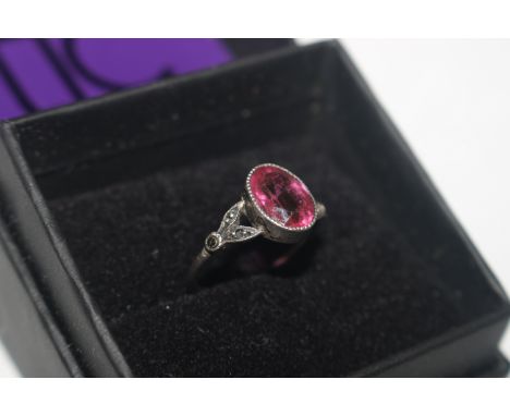 A white metal ring set marcasite and pink coloured stone 