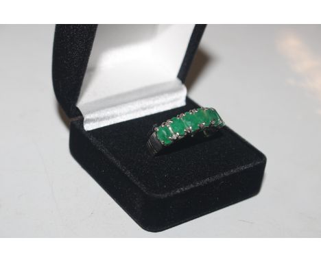 A 925 silver ring set with emerald coloured stones 