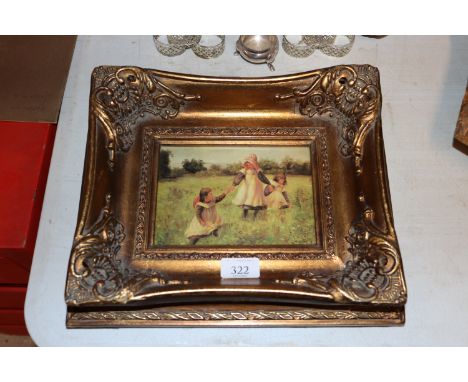 A gilt framed oleograph depicting children playing 