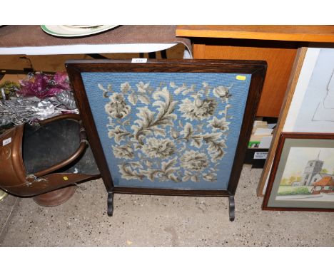 An oak and glazed needlework firescreen 