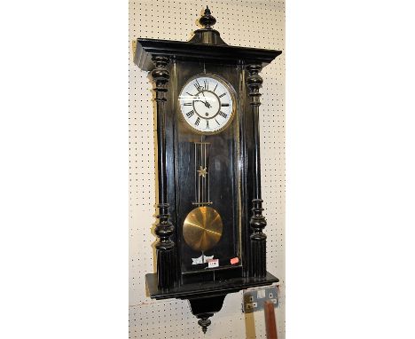 A late 19th century Vienna black painted drop trunk wall clock, having a white enamel dial