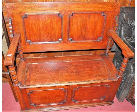 A circa 1900 geometric moulded oak twin panelled fold-over monks bench, having hinged box seat base with bobbin turned arm su