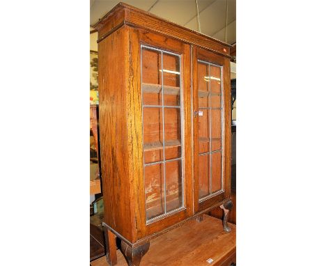 A 1930s oak and lead glazed double door bookcase, width 76cm. Height 112cm.Inner shelf depth 18cm.
