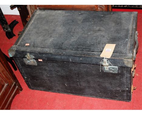 A canvas clad, metal bound and further studded travelling trunk, having hinged front panel and twin end carry handles, w.75cm