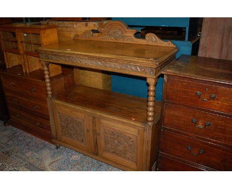A circa 1900 floral relief carved oak ledgeback buffet, having bobbin turned supports over twin lower cupboard doors, width 1