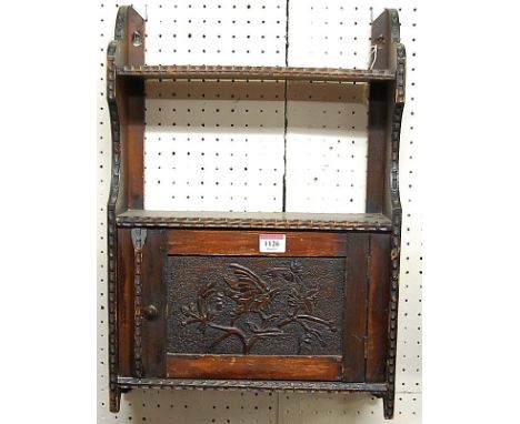 A late 19th century relief carved oak small single door hanging wall cupboard, having integral upper shelf, width 35.5cm