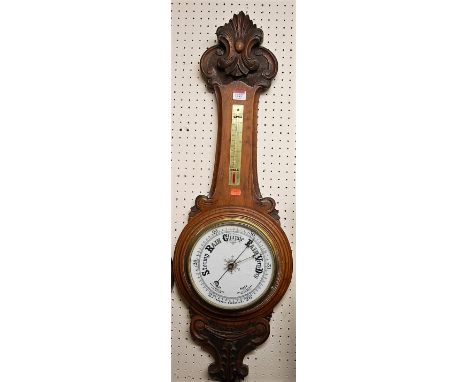 An early 20th century carved oak aneroid two dial wheel barometer