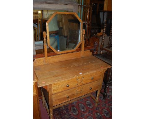 An early 20th century light oak swing mirrorback two drawer dressing chest, on bobbin turned supports, w.106cm