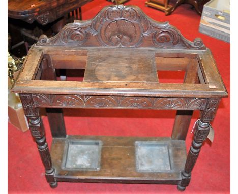 A circa 1900 line carved oak ledge back twin division stick stand, width 76cm