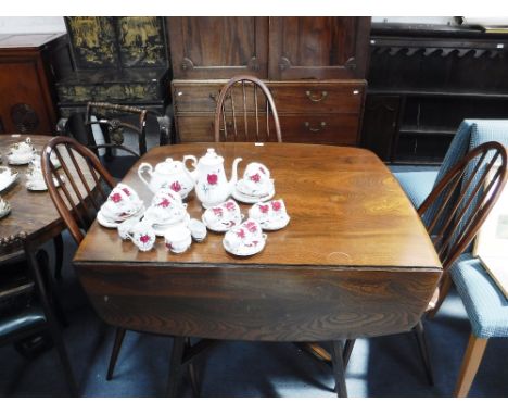 ERCOL: AN ELM DROP FLAP DINING TABLE AND THREE CHAIRS