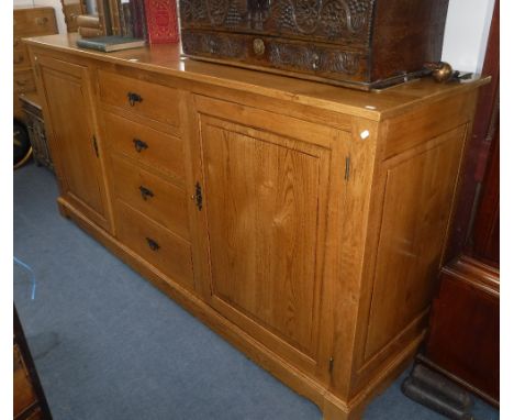 A REPRODUCTION PALE OAK BUFFET with fielded panel doors either side or drawers, of large proportions, 93" wide