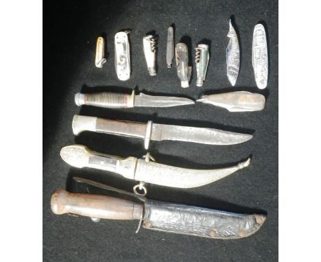 A KUKRI TYPE DAGGER with cast metal scabbard, stamped 'Syria', three other bladed weapons and a collection of folding pocket 