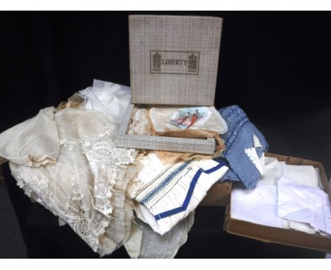 A CHILD'S VINTAGE LACE DRESS, a collection of similar clothes and a quantity of linen including hand painted mats in a 'Liber