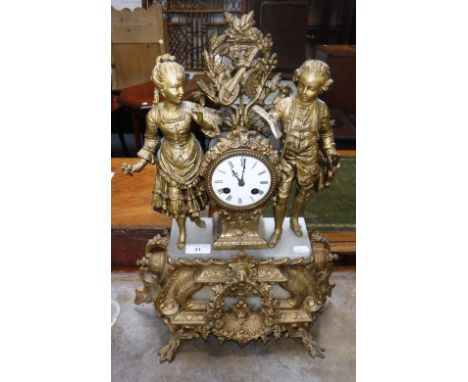 A FRENCH GILT METAL AND ALABASTER MANTEL CLOCK, with figures standing each side of the enamel dial, 19th century, 19" high