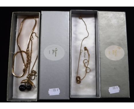 A CHRISTIAN DIOR CHERRY PENDANT AND CHAIN and another gold coloured chain, in original box and a similar Christian Dior penda
