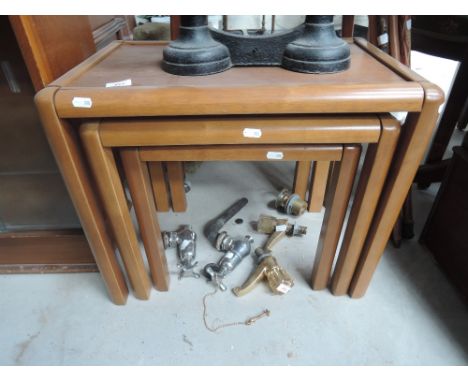 A vintage teak effect nest of three tables