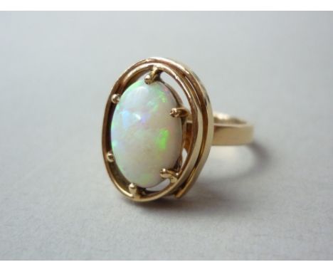 A contemporary opal cocktail ring, the oval cabochon stone of approximately 1.65ct, collet and crown set high above the shank