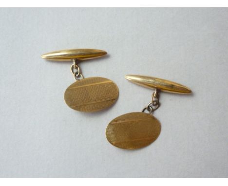 A pair of vintage 9 ct gold cuff links, each having a banded engine-turned oval face with torpedo back, 2.4 g 